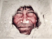 a close up of a man 's face with a fur hood on