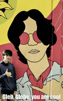 a man giving a thumbs up in front of a painting of a man with red glasses