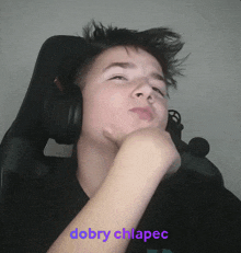 a boy wearing headphones with the words dobry chlapec written on the bottom