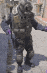 a man in a gas mask and purple gloves stands on a street