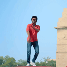 a man in a red shirt and blue jeans is dancing