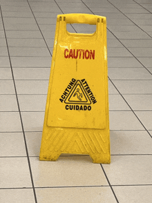 a yellow caution sign is on a tile floor