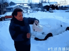 a man in a blue jacket is standing in front of a car in the snow