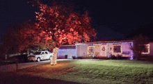 a white truck is parked in front of a house that has christmas lights on it