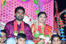 a man and a woman are posing for a photo with their children