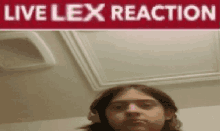 a man wearing headphones stands in front of a sign that says " live lex reaction "