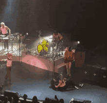 a group of people are playing instruments on a stage including a drummer