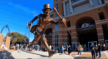 a statue of a man in a top hat and cane is in front of a building that says army field