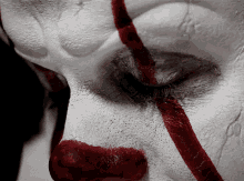 a close up of a clown 's face with red lines