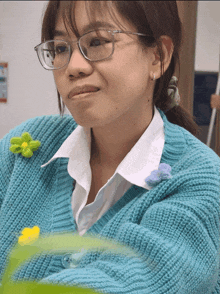 a woman wearing glasses is wearing a blue sweater