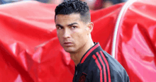 a close up of a man wearing a black and red adidas jacket