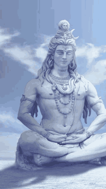 a statue of shiva sits in a lotus position with a blue sky in the background