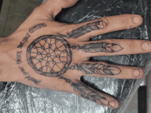 a hand with a tattoo of a dream catcher and the words " do n't go against your dreams "