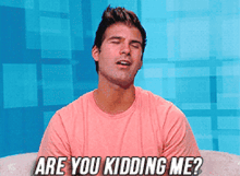 a man in a pink shirt is saying are you kidding me