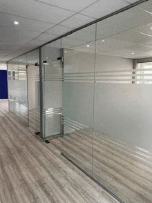 a hallway with glass walls and wood floors