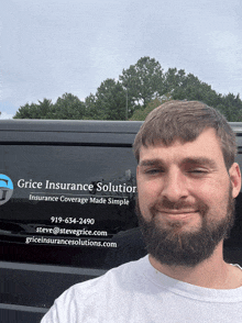 a man with a beard stands in front of a vehicle that says grice insurance solution