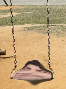 a man 's face is on a swing with chains