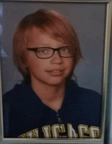 a young man wearing glasses and a chicago shirt