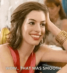 a woman in a red dress is smiling and holding her hand to her forehead .