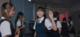 a group of girls are standing in a dark room and one girl is smiling