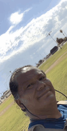 a man wearing a blue shirt and ear buds smiles for the camera