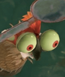 a close up of a cartoon bird with big green eyes and a spoon in its mouth .