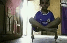 a young boy is sitting on the floor with his legs crossed and his feet crossed .