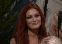 a woman with red hair and a cbs logo in the background