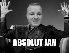 a man in a suit is sitting in a chair with his hands in the air and the words absolut jan written below him