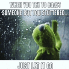 a kermit the frog is standing in front of a window with rain drops .