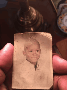 a person holding a picture of a young boy