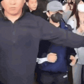 a man wearing a mask is being escorted by a security guard while holding a fork in his hand .