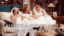 three women in wedding dresses are sitting on a couch drinking beer and eating popcorn ..