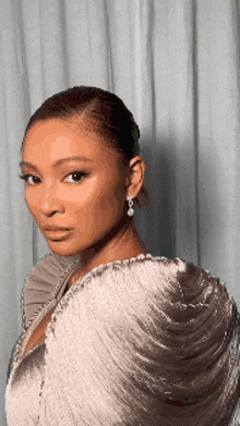 a close up of a woman 's face wearing a white dress and earrings