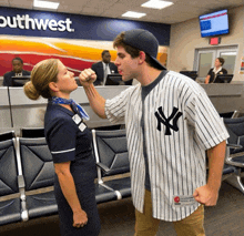 a man in a new york yankees jersey holds a woman 's fist