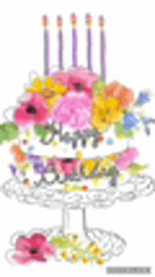 a birthday cake decorated with flowers and candles on a cake stand .