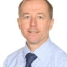 a man is wearing a blue shirt and tie and smiling .