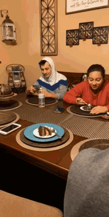 two people sit at a table with plates of food and a sign that says " and the love between "