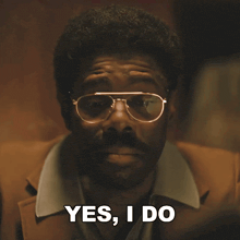 a man wearing glasses and a brown jacket says yes i do