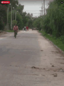 a person riding a bike down a road with a red sign that says " guardar "