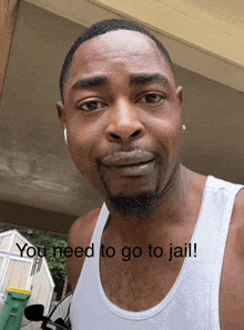 a man in a white tank top has the words " you need to go to jail " on his chest