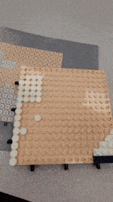 a person 's hand is holding a piece of lego that has numbers 1 through 2 on it