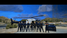 a group of police officers are posing for a photo in front of a helicopter