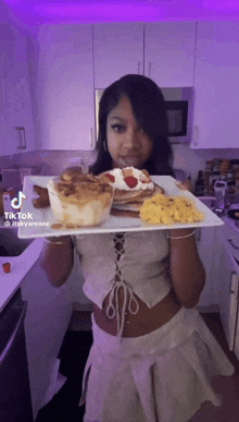 a woman is holding a plate of food with a tiktok logo on it