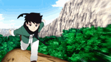 a boy in a green shirt and white pants is standing on a rock