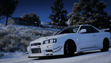 a white sports car is driving down a snow covered road