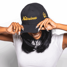 a woman wearing a black hat that says notorious