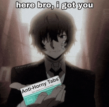 a man holding a box of anti-horny tabs in his hand