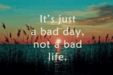 a picture of a sunset with a quote that says it 's just a bad day not a bad life