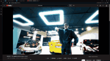 a screenshot of a video on youtube shows a man standing in front of cars